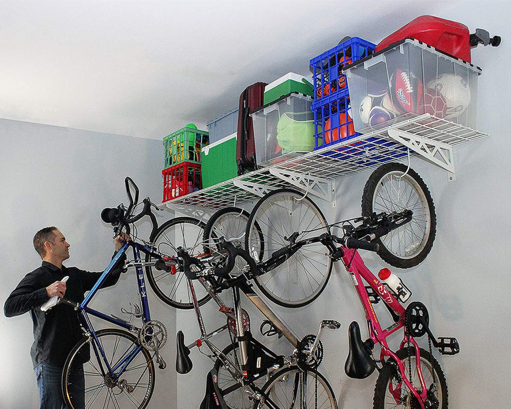 person removing bicycle from wall shelves