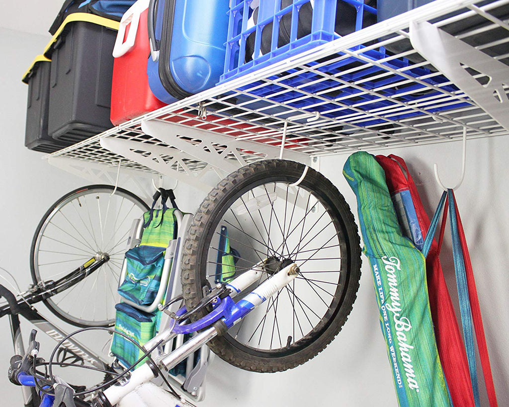 close up of bicycle and chairs hanging from wall shelf hooks