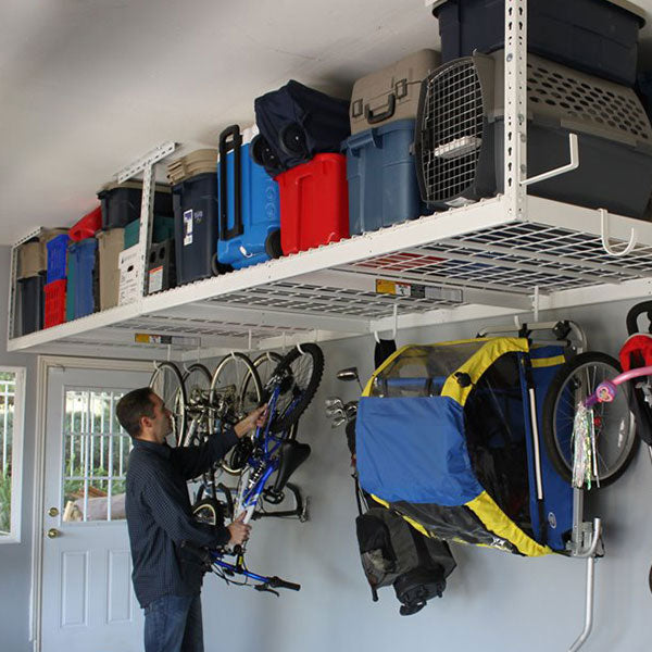 person removing bicycle from loaded overhead rack